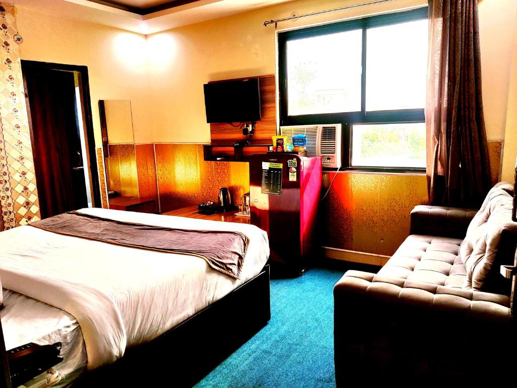 una camera d'albergo con letto e divano di Tulsi Garden- Near Prem Mandir Vrindavan a Vrindāvan