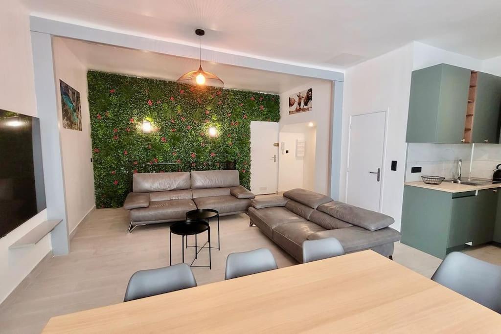 - un salon avec un canapé et un mur vert dans l'établissement Grand T5 avec patio et Sauna à 5mn à pied de la Plage des Catalans, à Marseille