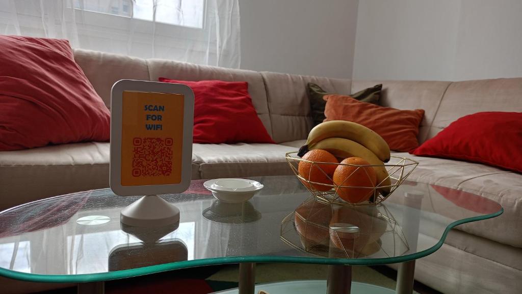 a sign on a glass table with a bowl of fruit at Clockwork orange apartment in Vračar (historical)