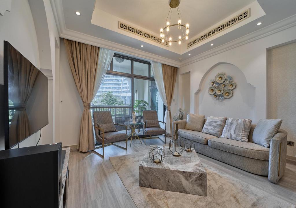 ein Wohnzimmer mit einem Sofa und einem TV in der Unterkunft Burj khalifa partial view Peak living luxury 2BR Souk AL-Bahar Beside Dubai mall-GOLDEN HOMES in Dubai