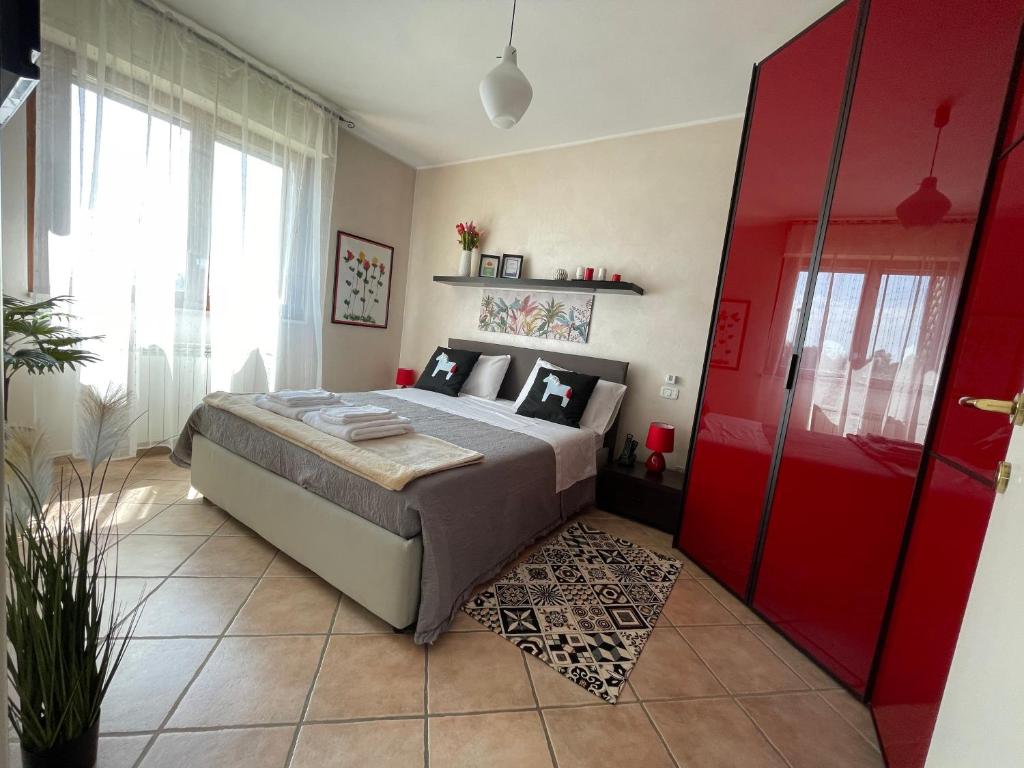 a bedroom with a bed and a red door at "CASA ADELIKA" Appartamento con GARAGE sulla via per il MARE in Grosseto