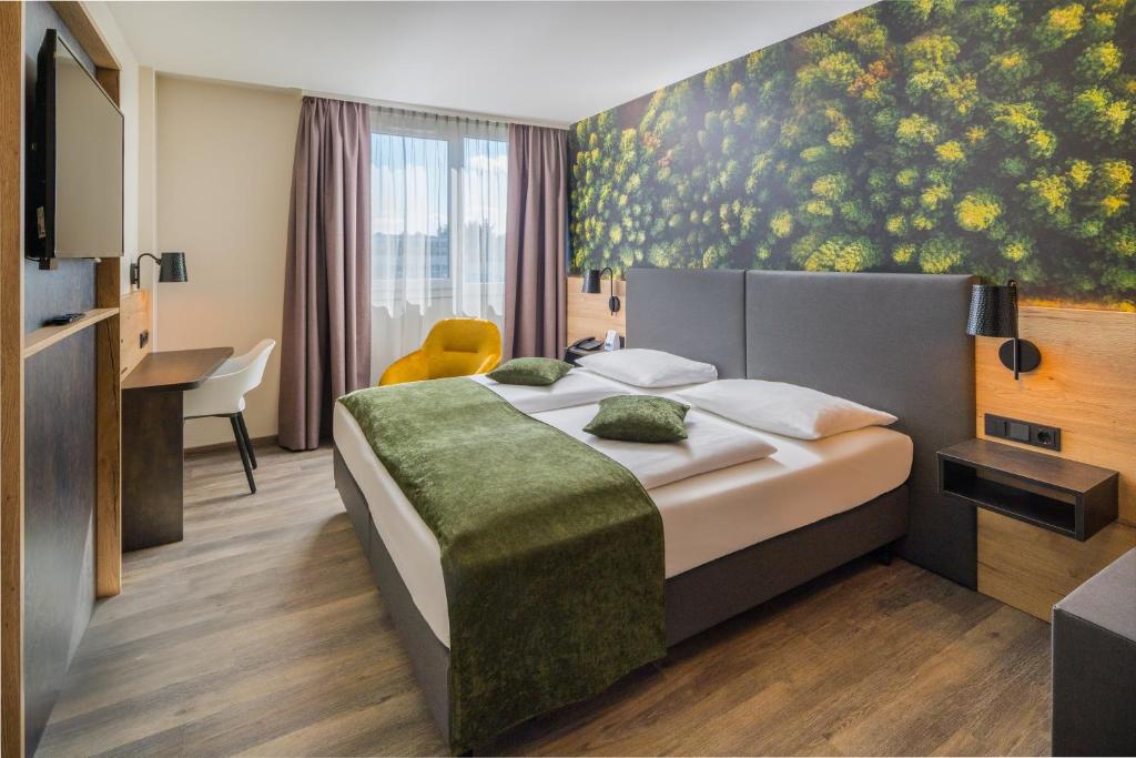 エルディングにあるベスト ウェスタン ホテル ミュンヘン エアポートのベッド付きの客室で、壁には絵画が飾られています。