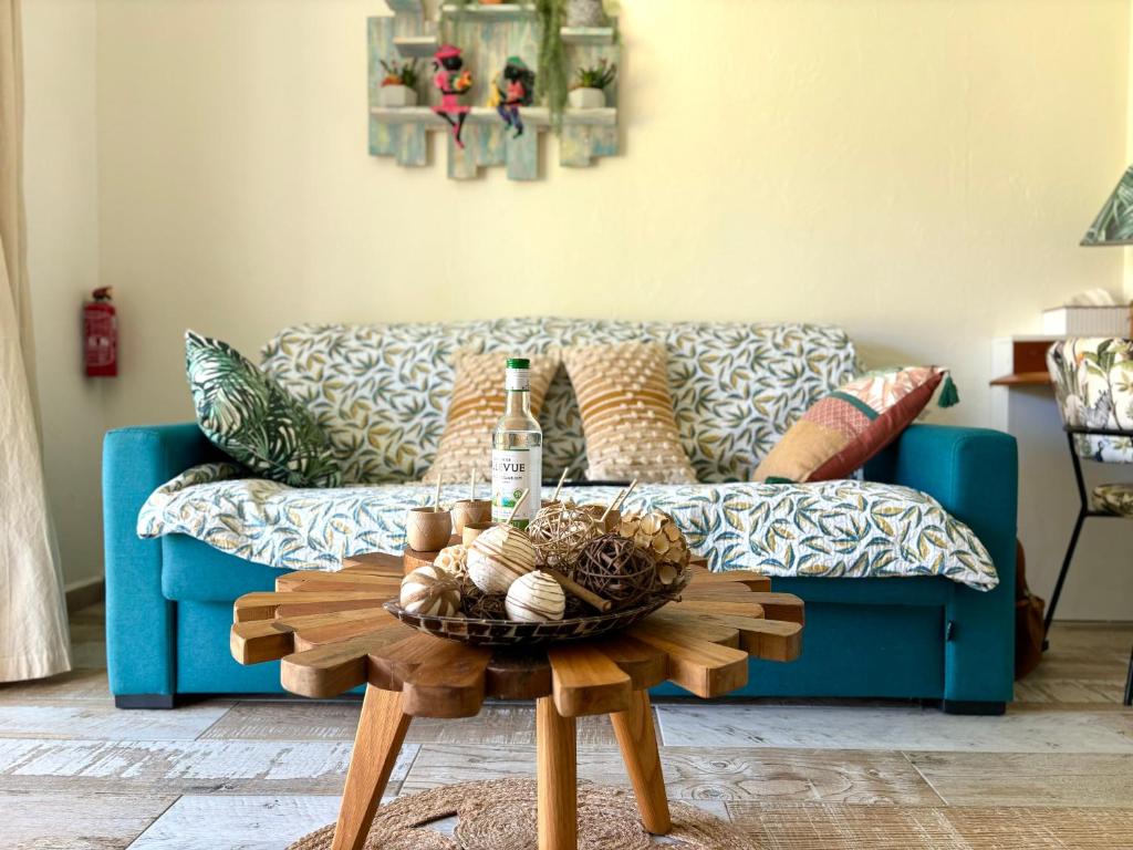 sala de estar con sofá azul y mesa en La Marigalantine - Piscine, Plage, Blue Dream en Grand-Bourg