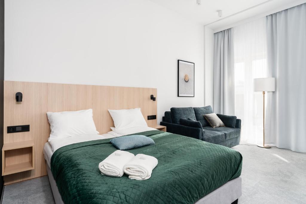 CityCenter Sauna & Fitness Apartments Podgórna by Renters Prestige في بوزنان: غرفة نوم بسرير كبير عليها مناشف