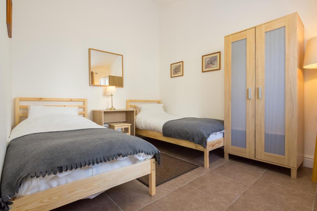 a bedroom with two beds and a mirror at Cambridge Water House Apartments in Cambridge