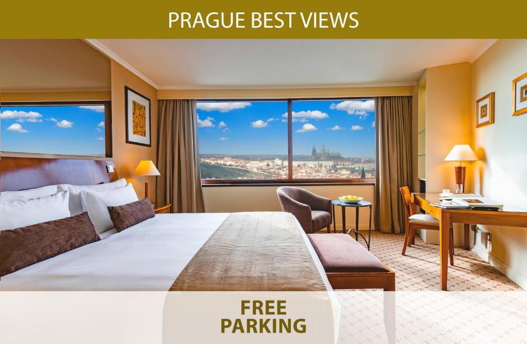 a hotel room with a large bed with a desk and a window at Grand Hotel Prague Towers in Prague
