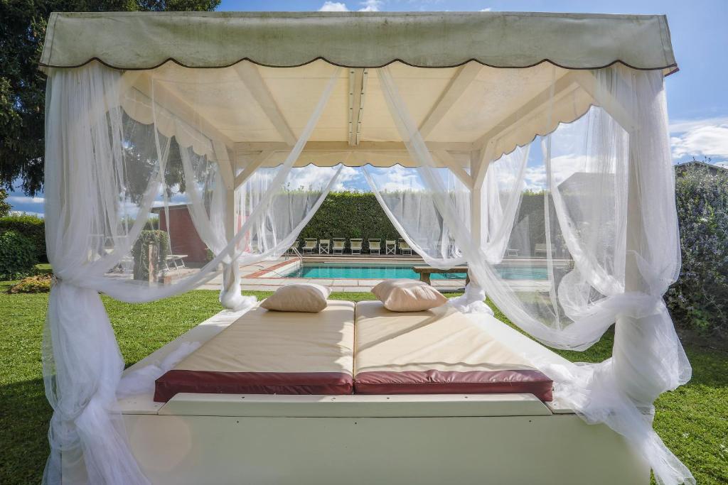 un letto a baldacchino in un cortile con piscina di HOME HILL a Capannori