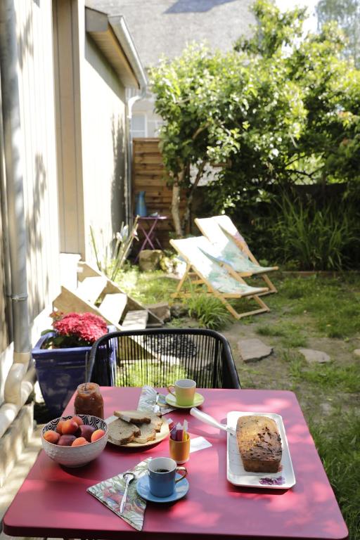 uma mesa rosa com comida em cima em la maison aux oiseaux em Lanvallay