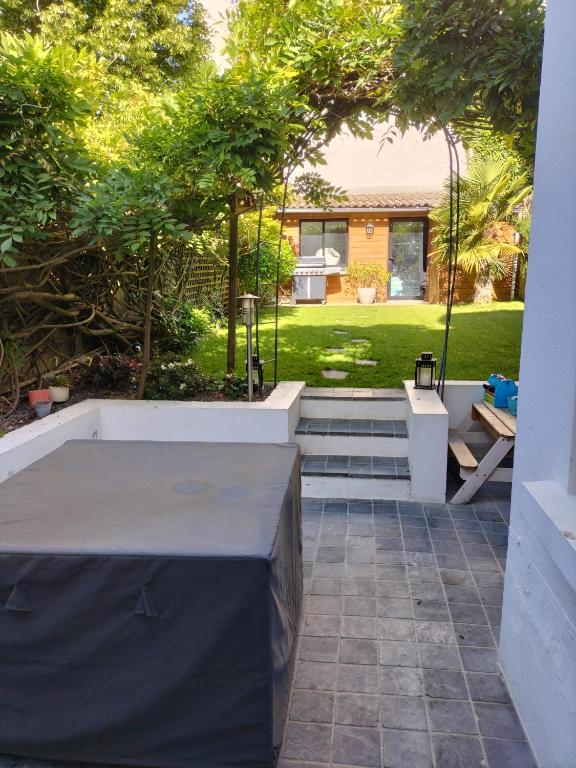 une table est dressée dans un patio avec une cour dans l'établissement Charmante maison de ville, au Mans