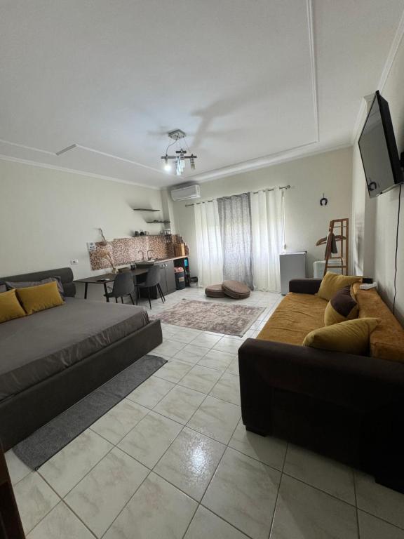 ein Wohnzimmer mit einem Sofa und einem Tisch in der Unterkunft Koa Studio Apartment in Korçë