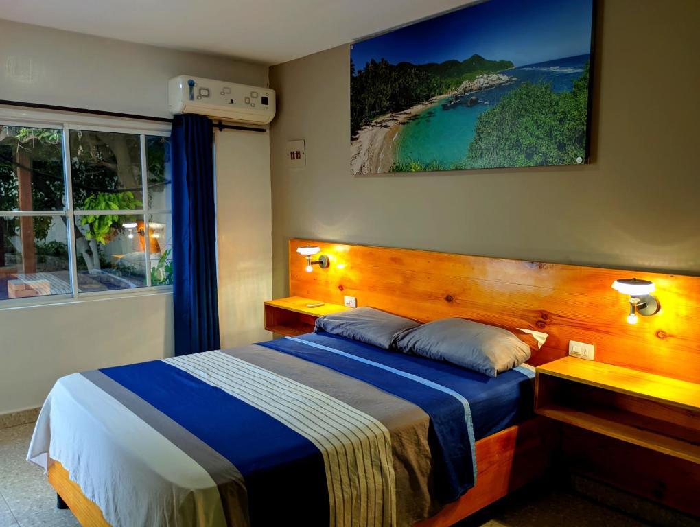 a bedroom with a bed with a picture on the wall at Villa Cabana Inn in Playa Dormida