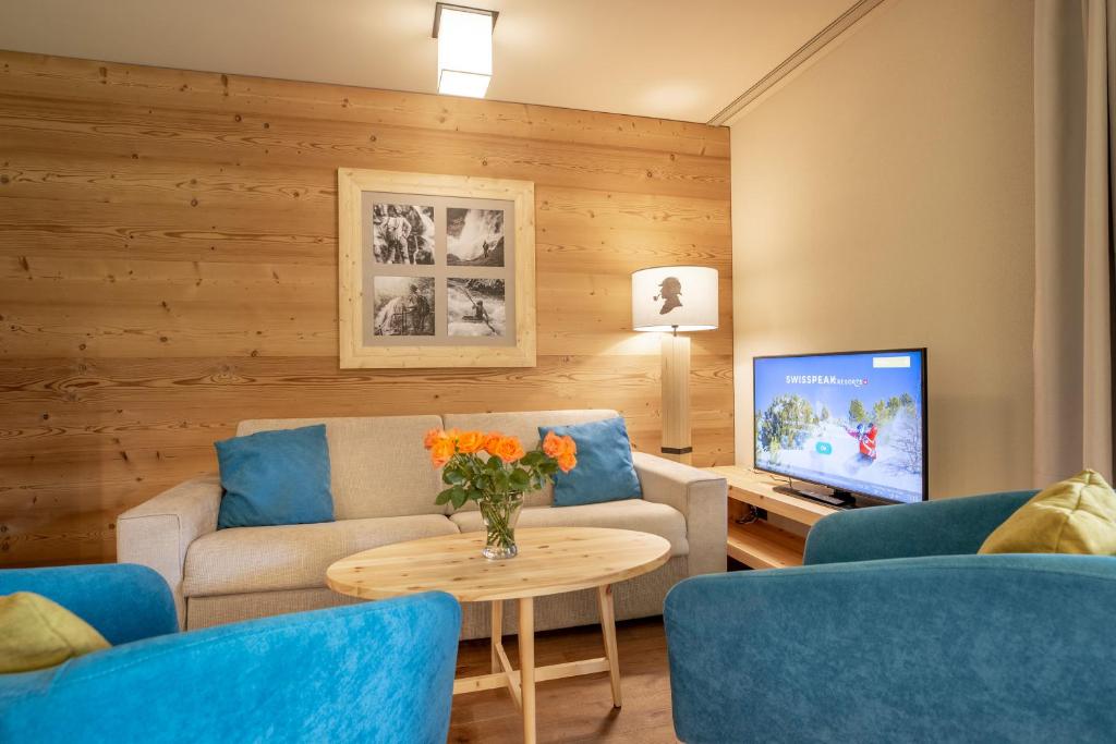 sala de estar con sofá y TV en SWISSPEAK Resorts Meiringen, en Meiringen