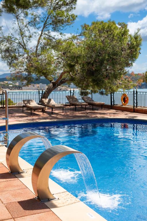a swimming pool with a water fountain at Hotel Cala Fornells in Paguera