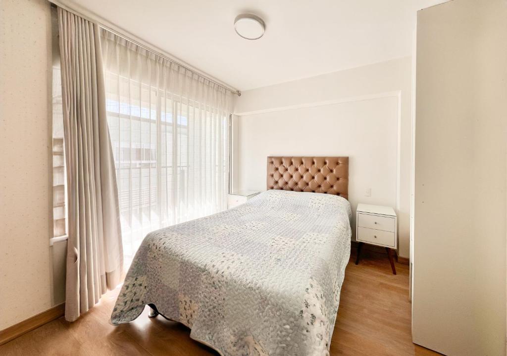 Un dormitorio con una cama y una ventana grande. en Nuevo Departamento en CentroHistórico de Arequipa, en Arequipa