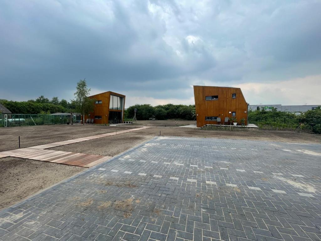 two wooden buildings sitting on top of a field at Casitas Wijchen - Nijmegen in Wijchen