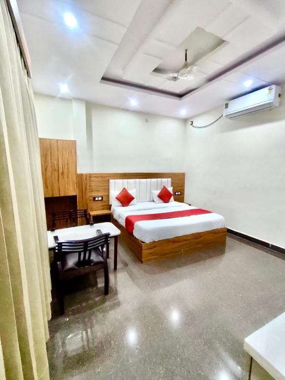 1 dormitorio con cama y escritorio. en Hotel Sarovar Regenta, en Mathura