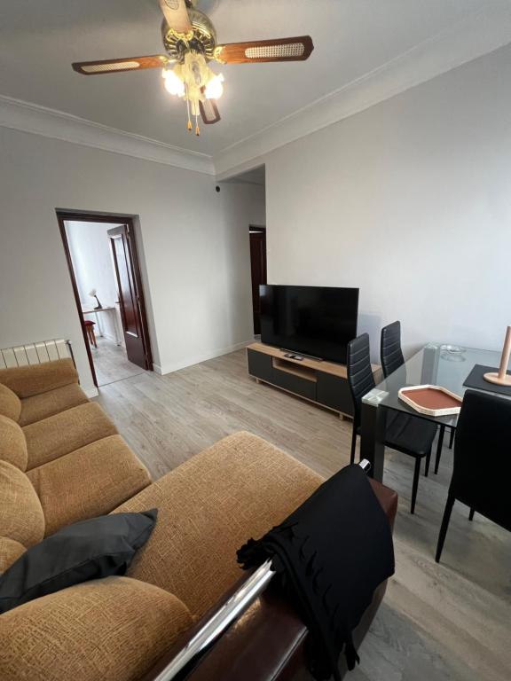 a living room with a couch and a tv and a table at 3 habitaciones reformado y centrico in Santander