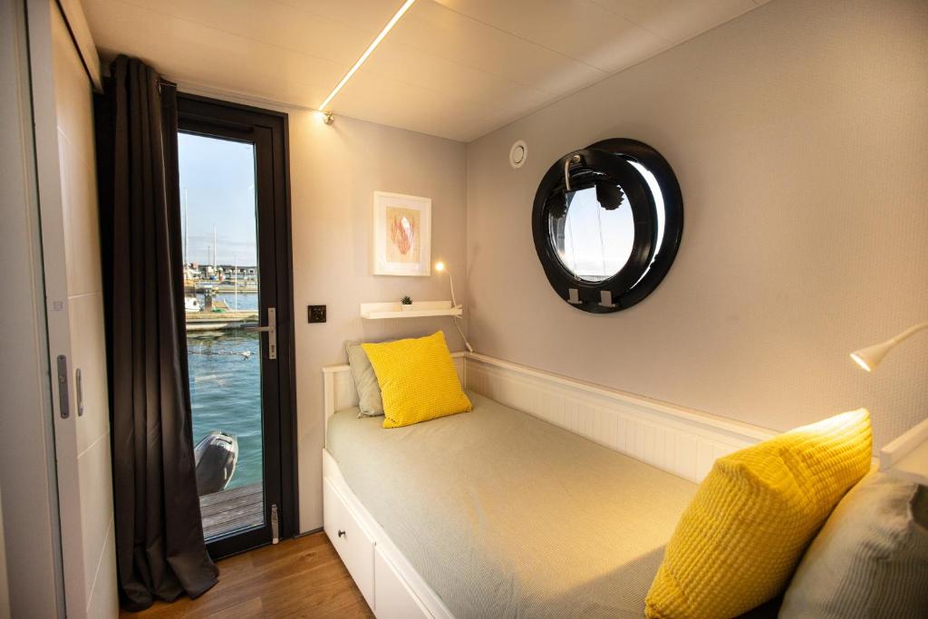 een kamer met een bank met een raam en een spiegel bij The Homeboat Company Sant'Elmo-Cagliari in Cagliari