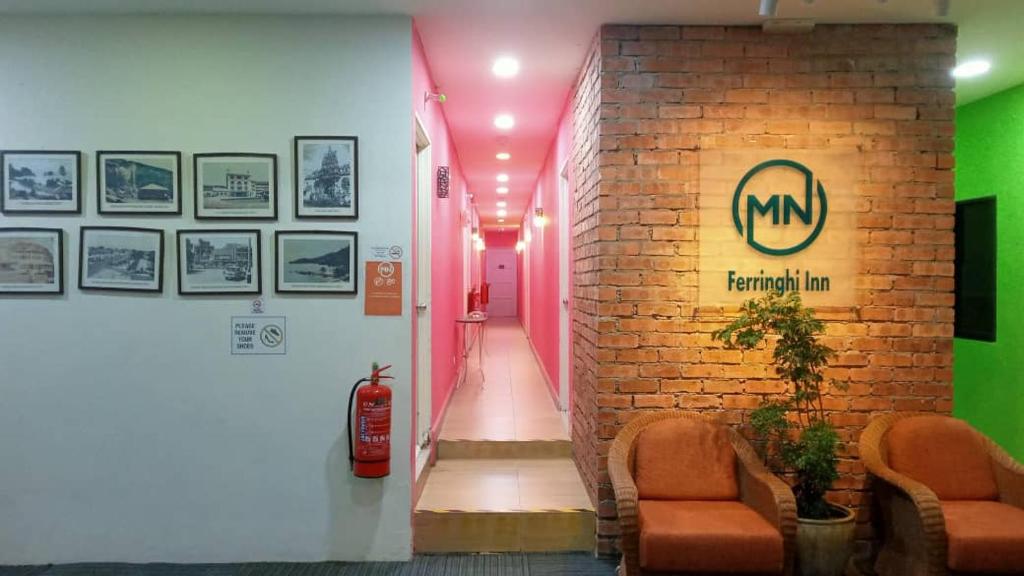 a hallway with two chairs and a brick wall at MN Ferringhi Inn in Batu Ferringhi