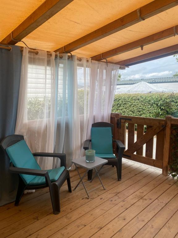 2 chaises et une table sur une terrasse dans l'établissement Mobil home de charme à la mer, à Fréjus
