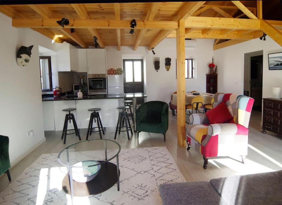 a living room with a table and chairs and a kitchen at Casa do Sol Nascente in Foz do Arelho