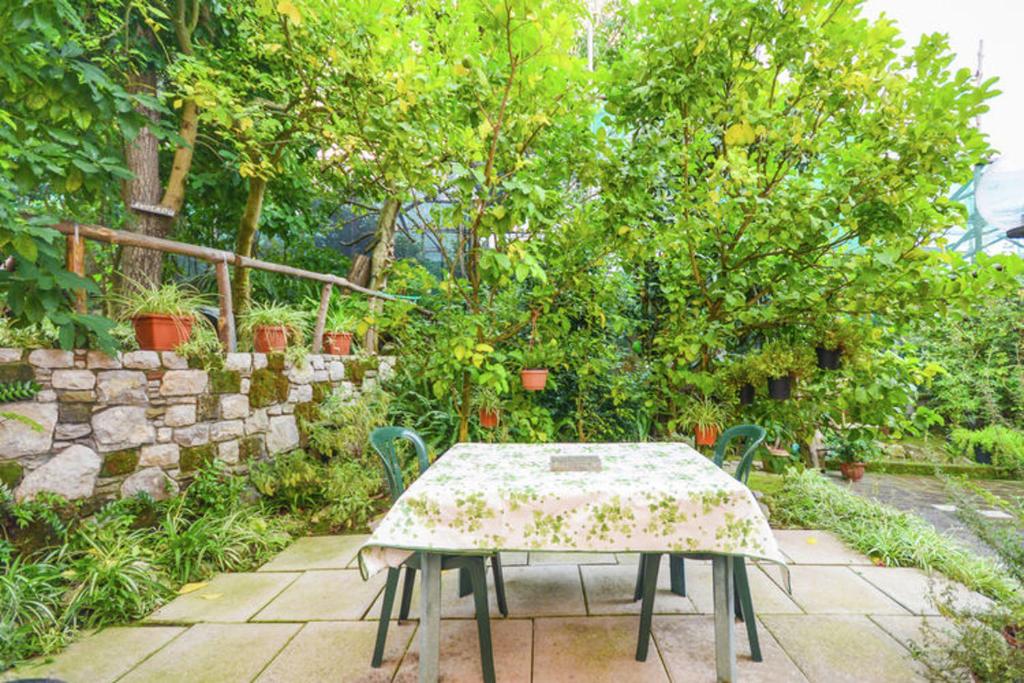 een tafel en stoelen in een tuin met bomen bij One bedroom house with sea view enclosed garden and wifi at Sorrento 1 km away from the beach in Sorrento