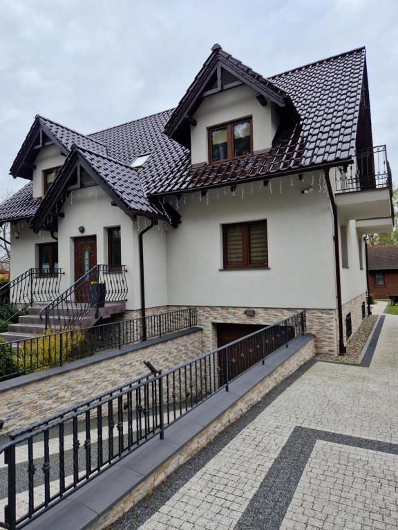 a house with a black roof at Domki i pokoje u Izabeli in Sztutowo