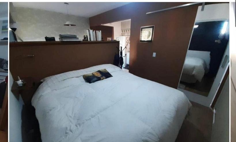 En eller flere senge i et værelse på Aconchegante apartamento
