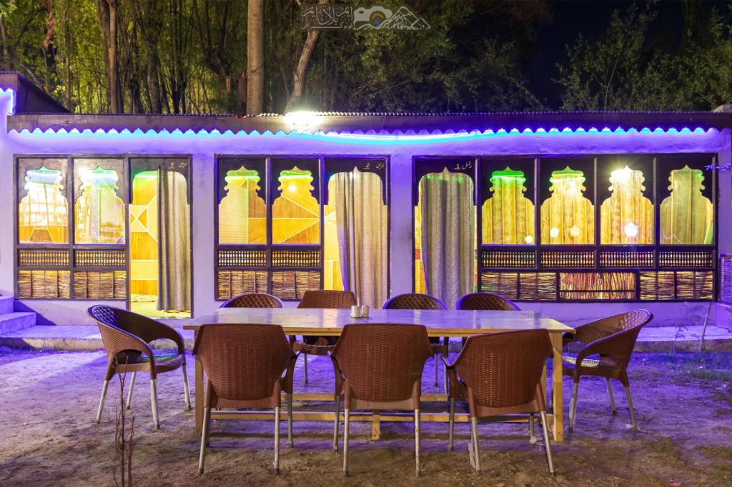 Ghanchi Inn Hotel في Dargai: طاولة وكراسي أمام عرض مزهريات