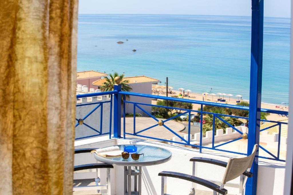 balcón con mesa y sillas y vistas a la playa en Villa Rozou, en Paralia Vrachou