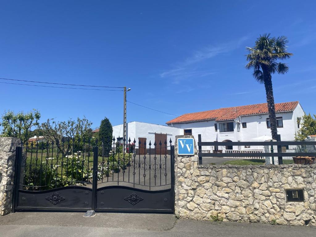 a gate in front of a house with a palm tree at Finca Robejones VV-511-AS in Colombres