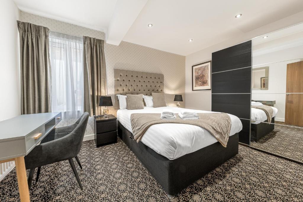 Pokój hotelowy z dużym łóżkiem i biurkiem w obiekcie Abbey Apartments Modern ApartHotel for Tourists & Professionals w mieście Barrow in Furness