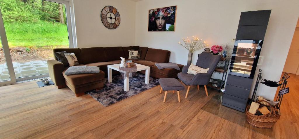 uma sala de estar com um sofá, cadeiras e uma mesa em Ferienhaus Waldblick em Hohenfels-Essingen