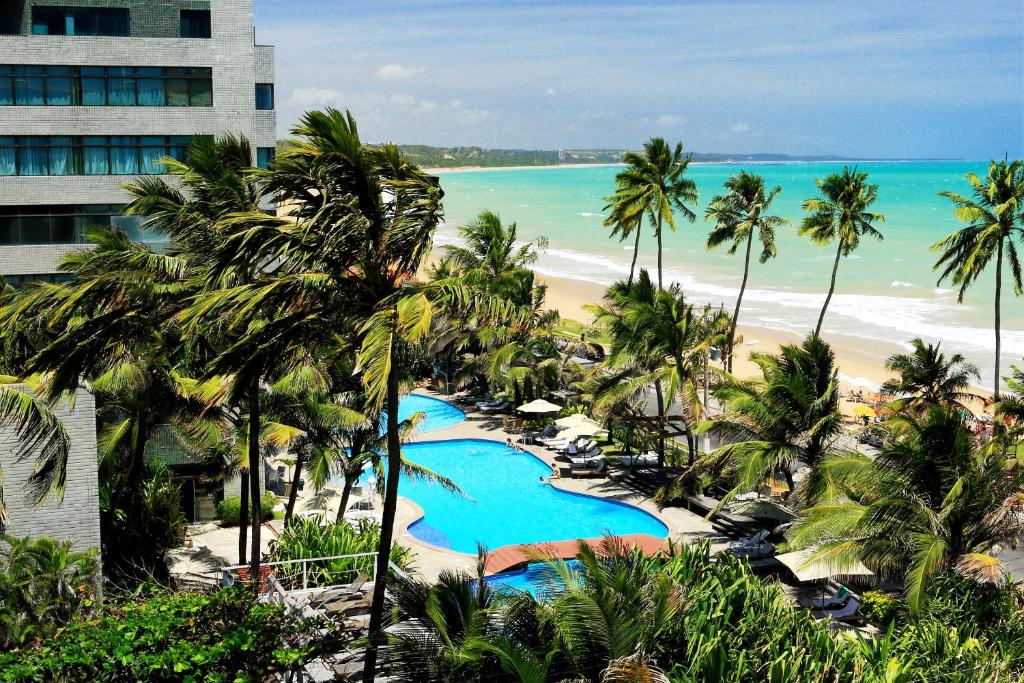 uma vista para a praia a partir da varanda de um resort em Ritz Lagoa da Anta Hotel & SPA em Maceió