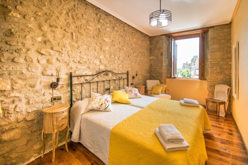 オリテにあるRonda del Castilloの石壁のベッドルーム1室(大型ベッド1台付)