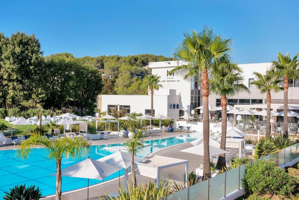 une image d'un hôtel avec une piscine et des palmiers dans l'établissement Mouratoglou Hotel & Resort, à Biot
