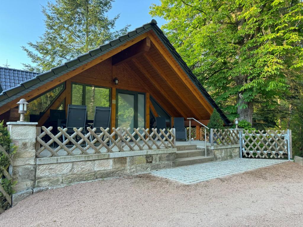 a house with a fence in front of it at Auszeit im Wald - mit Schwimmbad! 