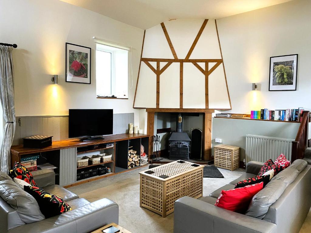 ein Wohnzimmer mit Couch und Kamin in der Unterkunft Horseshoe Cottage Aberaeron in Ciliau-Aeron