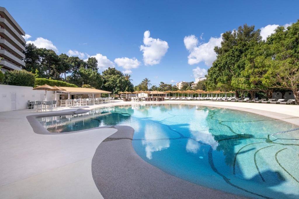 - une piscine d'eau bleue dans un complexe dans l'établissement Salles Hotels Marina Portals, à Portals Nous