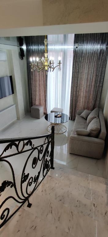 Una sala de estar con un sofá y una lámpara de araña. en Mimino T&G, en Tiflis