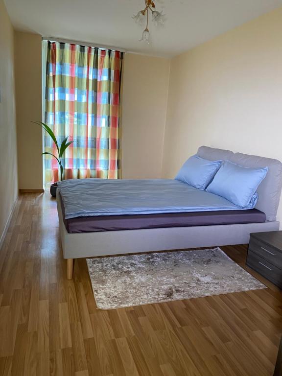 a bedroom with a bed with blue sheets and a window at Vita apartment in Vilnius