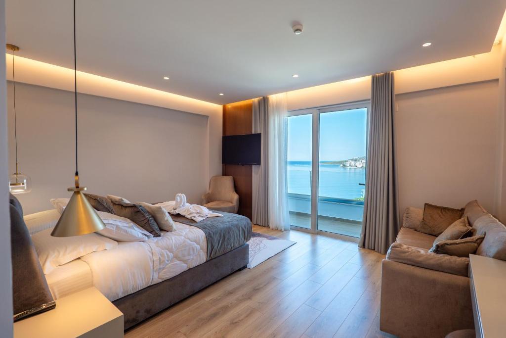 a bedroom with a bed and a couch and a window at Hotel Oasis in Sarandë