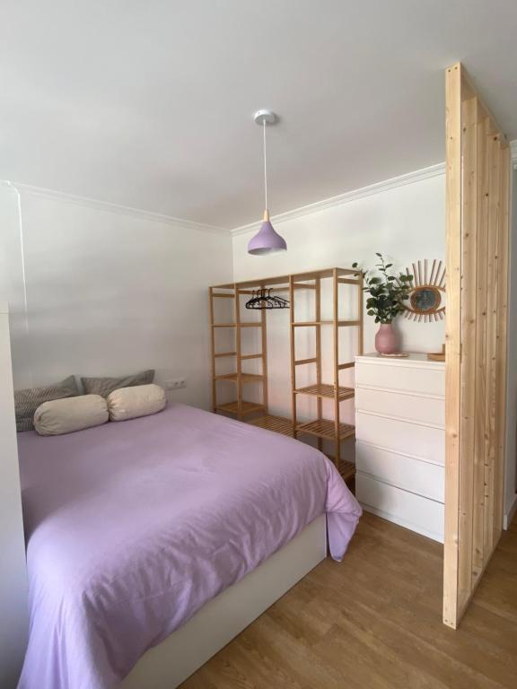 a bedroom with a bed with a purple blanket at Rincón de Beluso, Bueu in Pontevedra