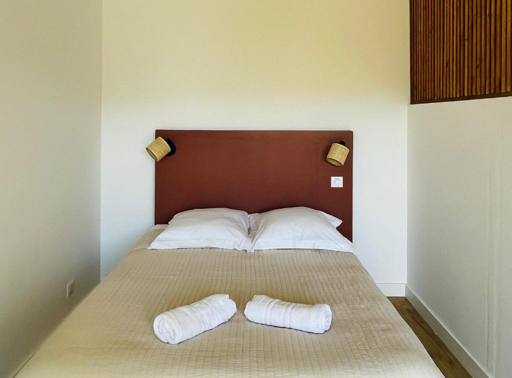 a bedroom with a bed with two pillows on it at Appartement l'orée du bois Ajaccio in Ajaccio