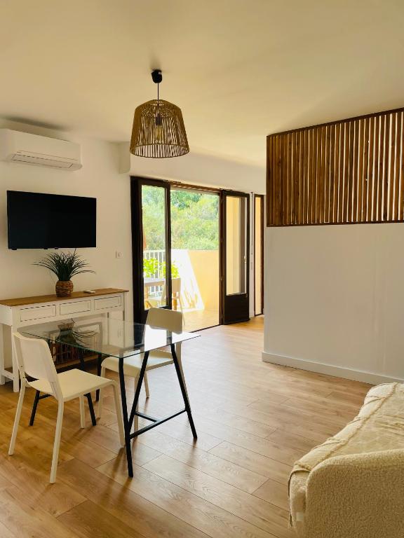 un salon avec une table en verre et un canapé dans l'établissement Appartement l'orée du bois Ajaccio, à Ajaccio