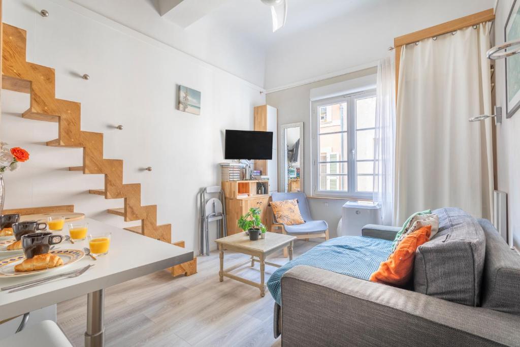 Studio cosy Aix en Provence في آكس أون بروفانس: غرفة معيشة بها درج وأريكة