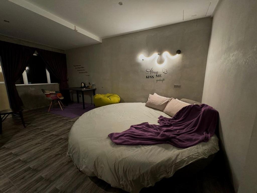 a bedroom with a bed with a purple blanket on it at Ipoh Zing Vale - Family & Couple Suite in Ipoh