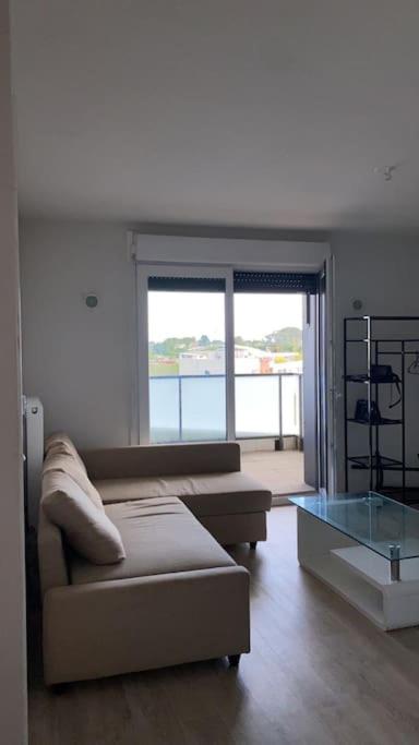 un salon avec un canapé et une table en verre dans l'établissement Appartement idéalement situé à2min à pied du Tram2, à Castelnau-le-Lez