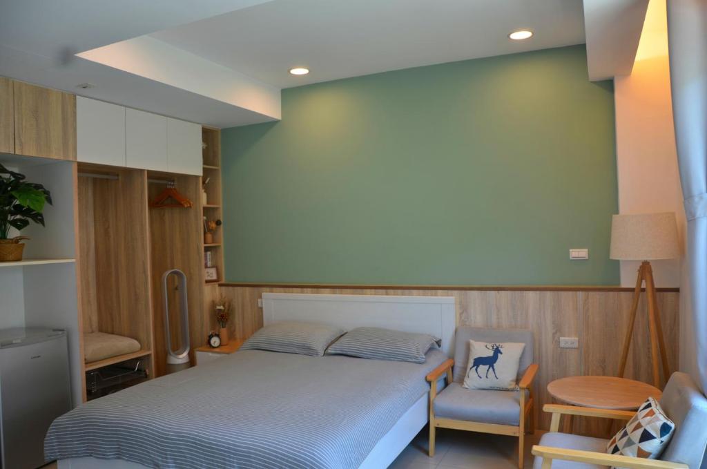 1 dormitorio con 1 cama y 1 silla en Blowing in the wind Homestay, en Jincheng