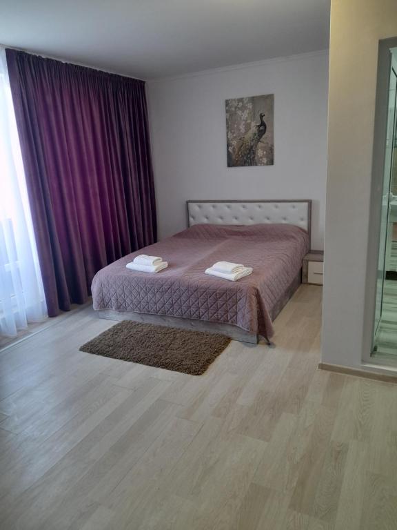 a bedroom with a bed and a purple curtain at 3 Room Penthouse Apartment with fantastic Seaview and big Terraces OASIS Ravda in Ravda